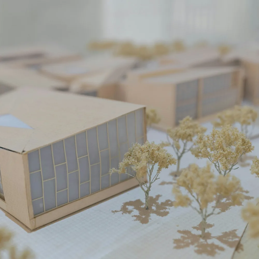 Architektonický model budovy z bílého a hnědého materiálu s viditelnými hranami desek